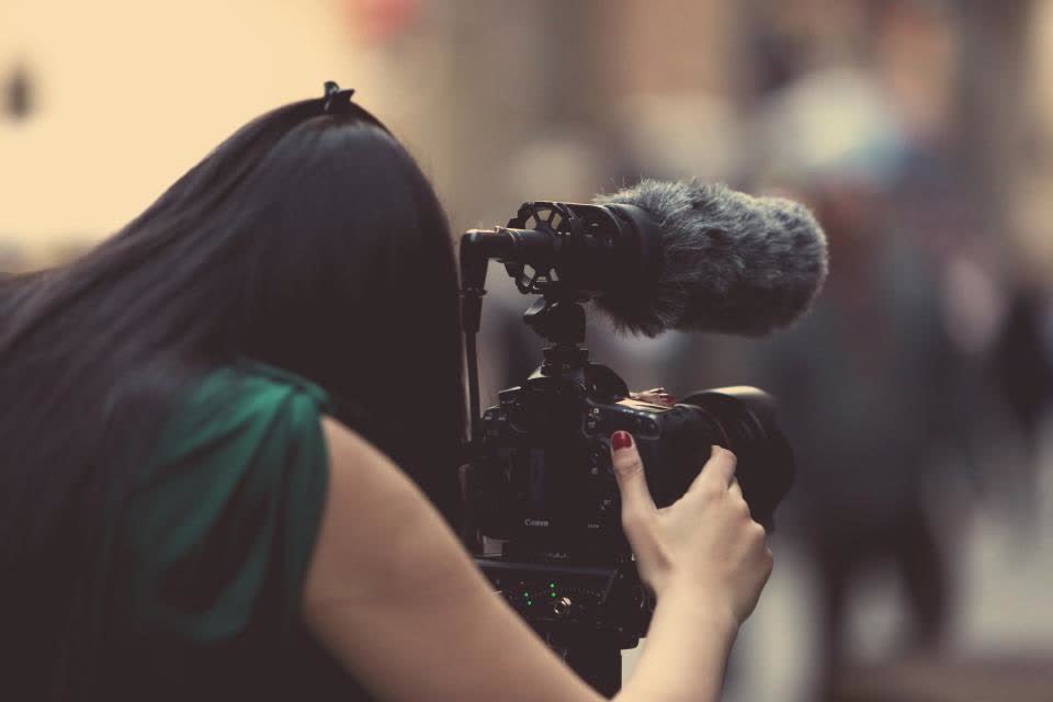 Fotograf profesionist lucrând cu aparatul de fotografiat în timpul unei ședințe